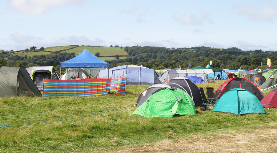 Een overzicht van diverse festivaltenten op een veld