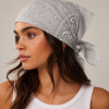 Grijze bandana gedragen door model – klassieke paisley bandana in grijs met witte print, gedragen als hoofddoek. Veelzijdig te stylen als haarband, nekdoek of accessoire. Ideaal als cadeau of festival- en zomeraccessoire.
