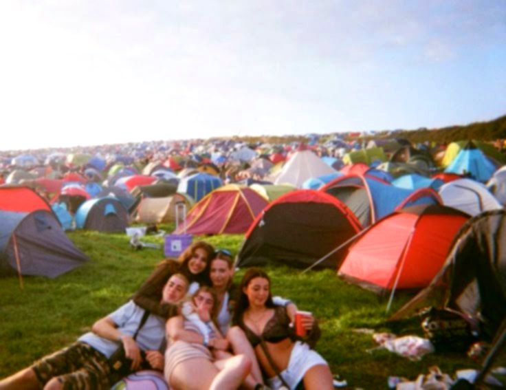 Groep vrienden voor hun tenten op de festivalcamping