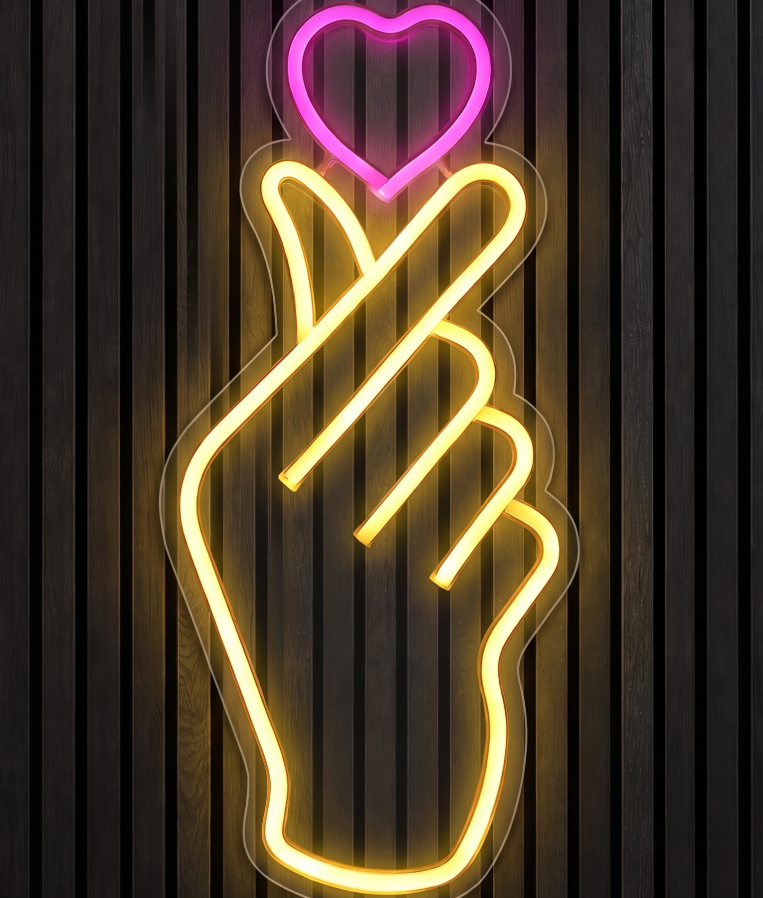 Hand met hartje neon lamp met een hand die een klein hartje maakt in geel licht