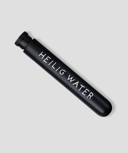 Ronde zwarte heupfles met de tekst Heilig water